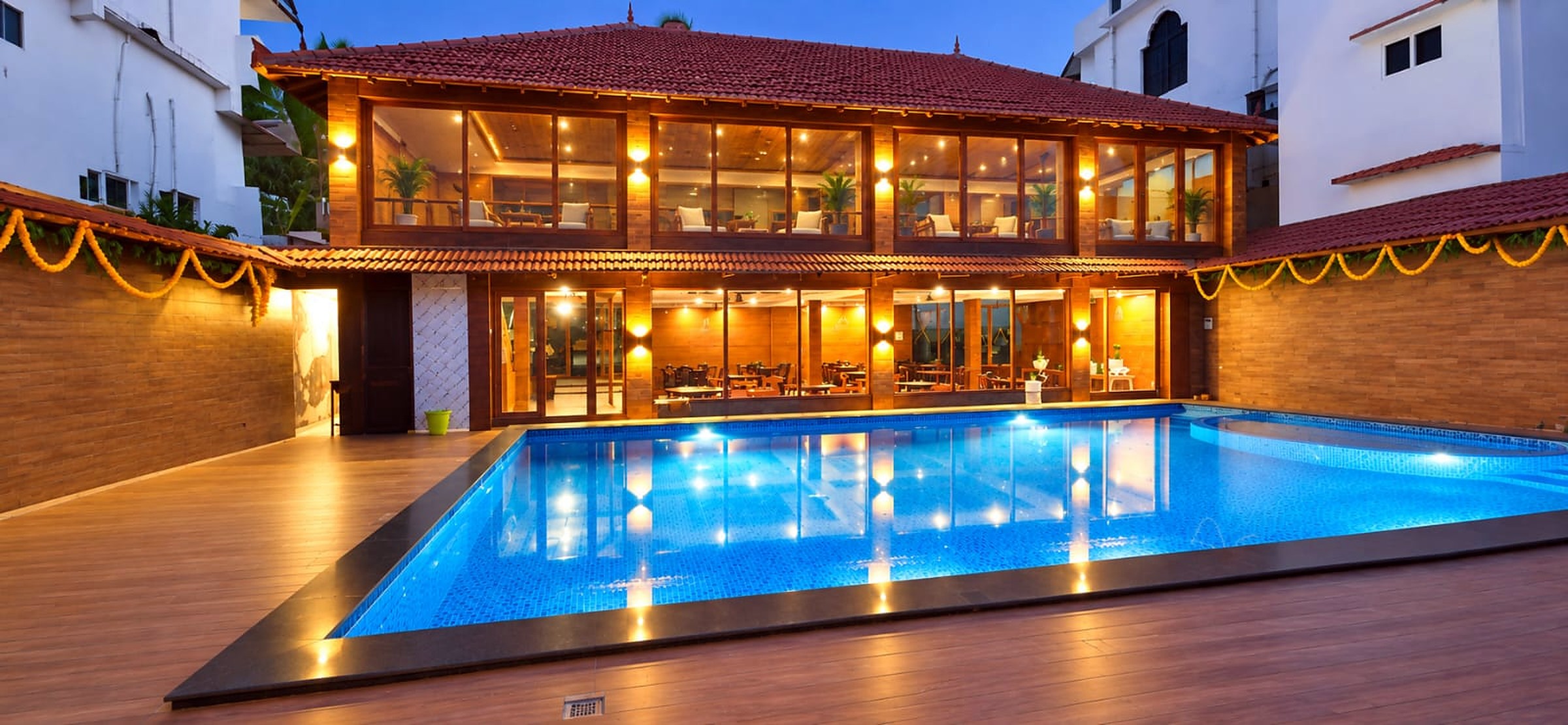 The pool at night, lit up in front of the glass-fronted restaurant