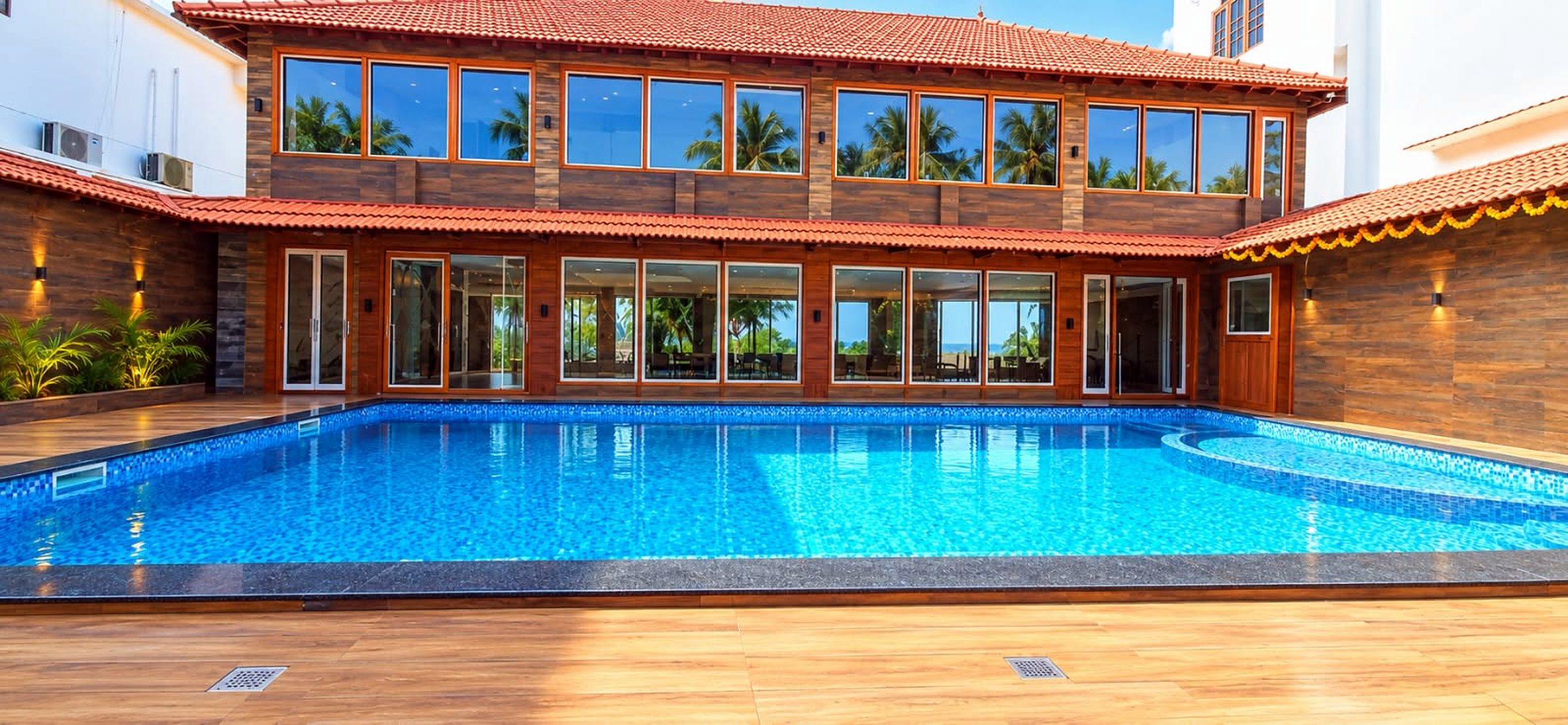 The pool in the morning sun, in front of the glass-fronted restaurant