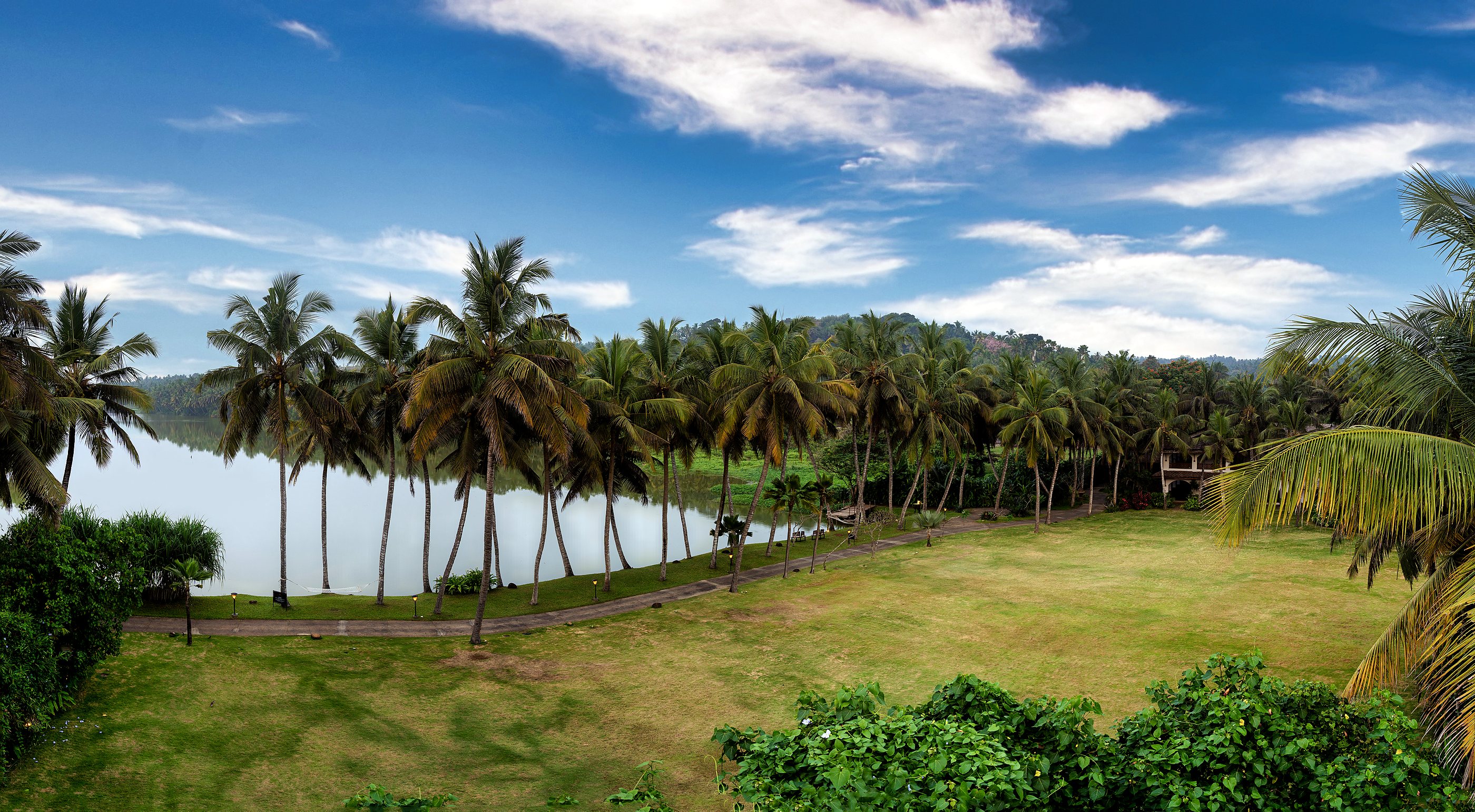 The view from the rear rooms: still water lined with coconut palms, and a wide lawn